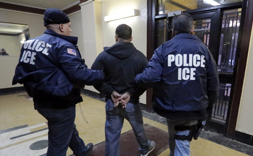 Immigration and Customs Enforcement officers escort a man who was arrested in a New York City apartment building. New York is a city that won't detain noncitizens on behalf of the federal government.