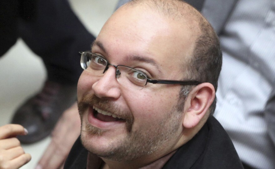 Jason Rezaian, an Iranian-American correspondent for The Washington Post, smiles as he attends a presidential campaign even for President Hassan Rouhani in Tehran in 2013. Rezaian, who was arrested in July, was charged by Iran on Saturday.