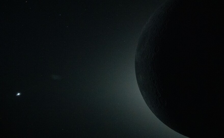 April 6: A close-up view from the Orion spacecraft during the Artemis II crew's lunar flyby captures a total solar eclipse, with only part of the moon visible in the frame as it fully obscures the sun. Although the full lunar disk extends beyond the image, the sun's faint corona remains visible as a soft halo of light around the moon's edge. From this deep-space vantage point, the moon appeared large enough to sustain nearly 54 minutes of totality, far longer than total solar eclipses typically seen from Earth.