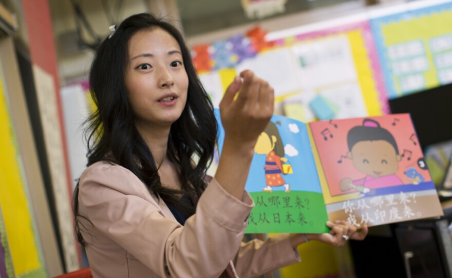 Teacher Tingting Mei reads a book in Mandarin to kindergarteners. Mei says repetition is how she helps her students master the language.