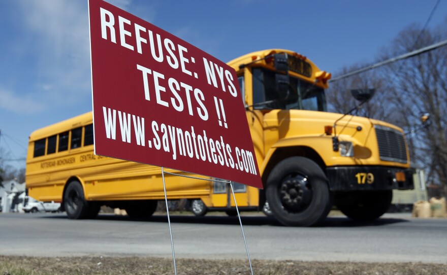 New York: A school bus passes a sign encouraging parents to refuse that their children take state tests in Rotterdam, N.Y.