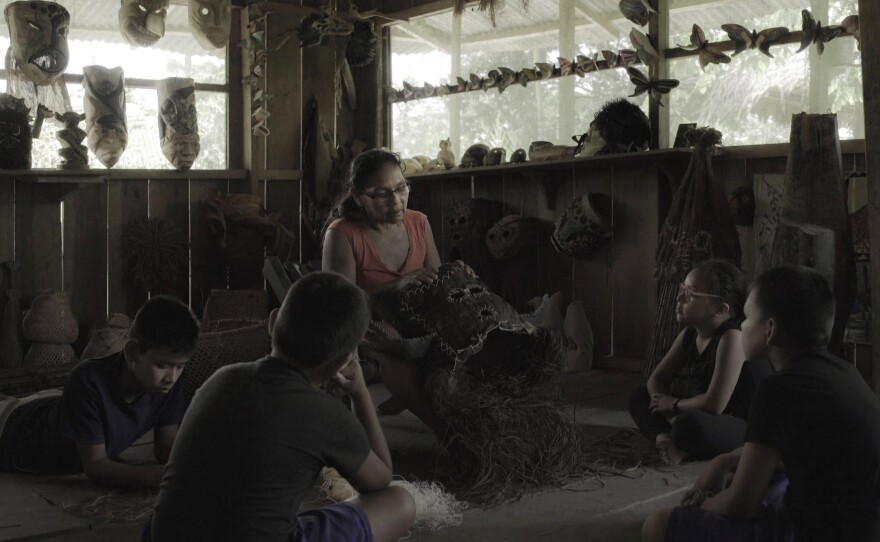 A woman and children sit in a circle as she shows them a mask. Indigenous painter Rember Yahuarcani pursues a successful career in Lima, but when he finds himself in a creative rut, he returns home to his Amazonian community and discovers why his ancestors' stories cannot be forgotten. 