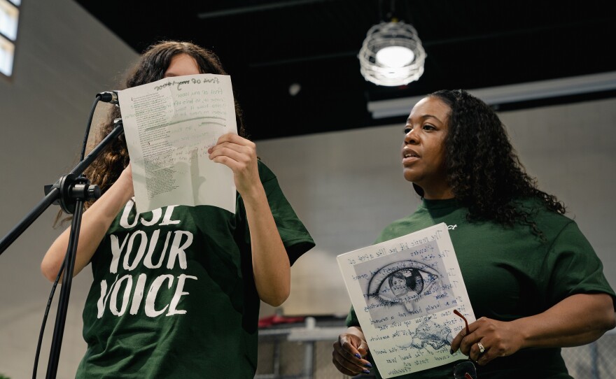 A Northern Virginia Juvenile Detention Center resident reads a poem alongside Sound Impact board member Keisha Johnstone.