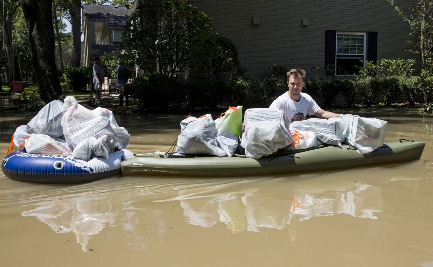 A resident tries to save some of his belongings from the flooded Buffalo Bayou in Houston.