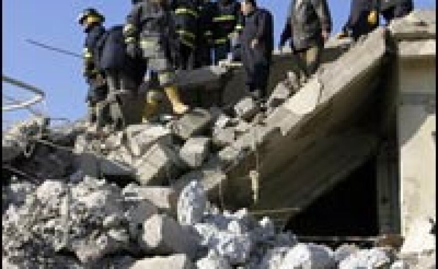 Iraqi firefighters search for wounded people amid rubble at the site of a deadly explosion in Mosul, Jan. 24, 2008.