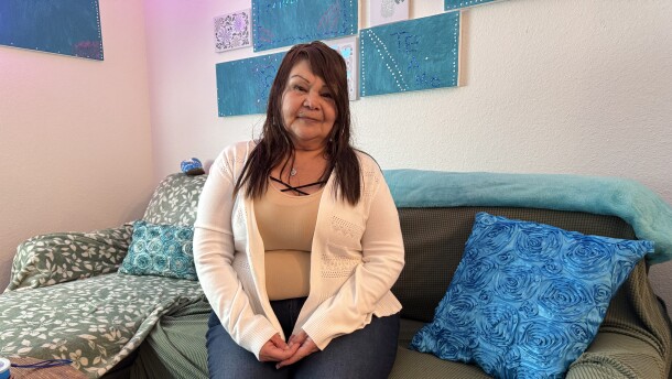 Isabelle Fuentes sitting in her one-bedroom apartment at Jacaranda on Ninth, an affordable housing complex in Cortez Hill downtown San Diego, May 7, 2026.