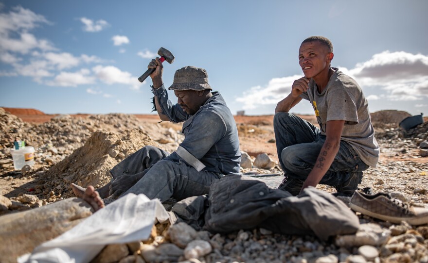 An ilegal diamond miner breaks up rocks at the Nuttabooi mine near Kleinzee, South Africa.