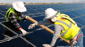Workers install First Solar panels in Blythe, CA.