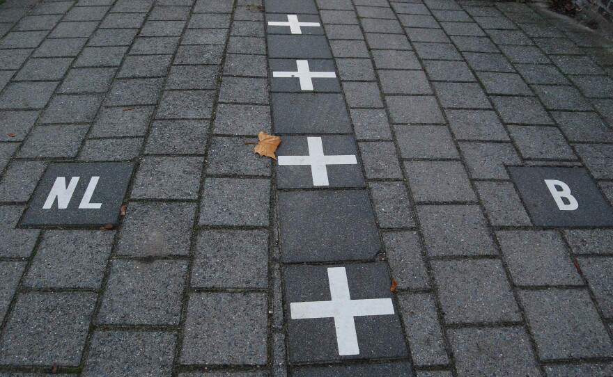 Netherlands and Belgium border painted on the sidewalk in Baarle-Nassau.