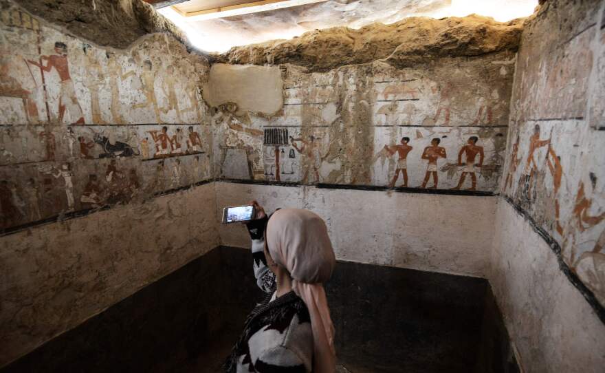 A woman takes a photo inside the tomb of an Old Kingdom priestess that was unveiled on Saturday after being discovered during excavation work in Giza's western cemetery by a team of Egyptian archaeologists.