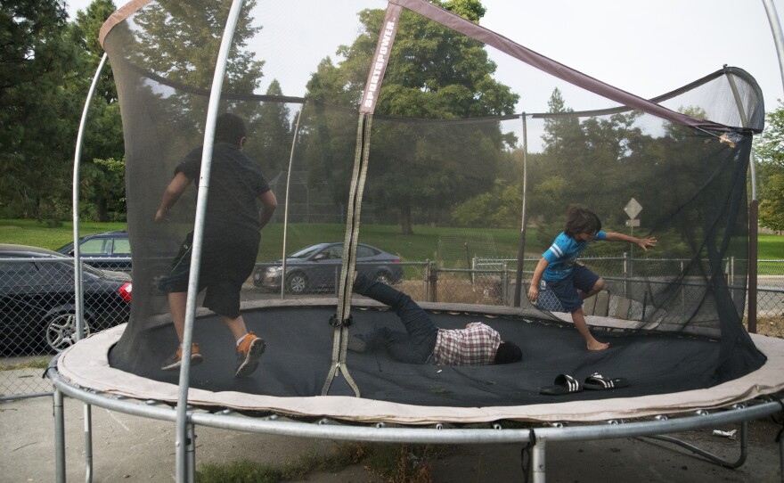 Three of Manuel and V's sons play on the trampoline in their backyard. Manuel was away from his family for six months.