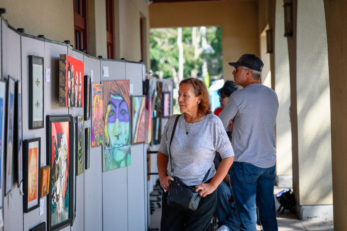 Visitors walk through an exhibit of paintings and other artwork at the inaugural Chula Vista Art Fest, outside Chula Vista City Hall, on Sept. 30, 2023.