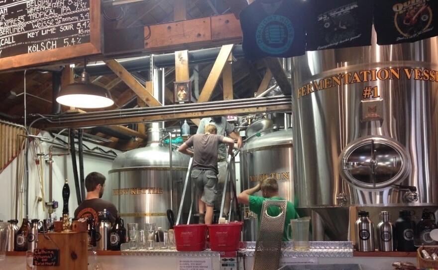 Brewers from Draught Works and the Denver Beer Co. collaborate on making a huckleberry sour beer last weekend at the Draught Works brewery in Missoula, Mont. The beer was kettle soured before being added to the fermentation tank seen here.