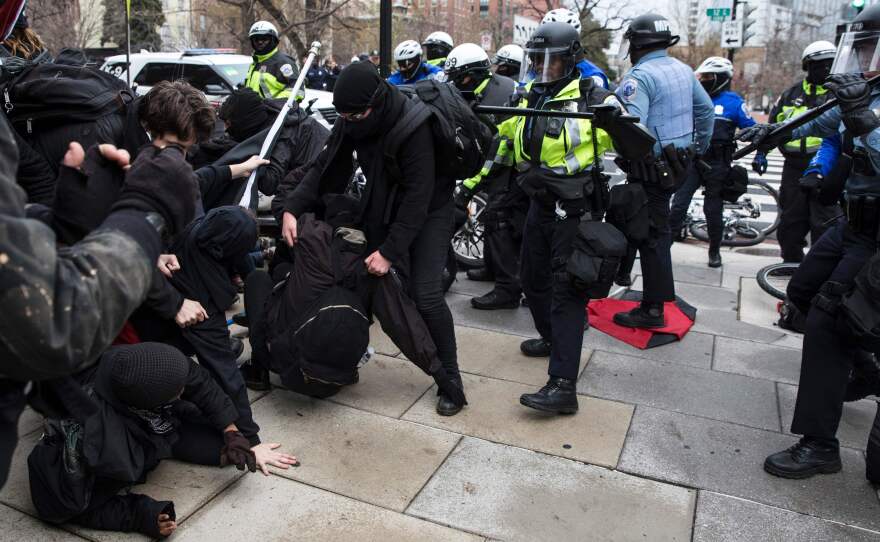 Police officers push a group of demonstrators back in Northwest Washington, D.C., on Friday. Violence broke out in the area among a crowd of several hundred, but the city's interim police chief says protests across the city have been largely peaceful.