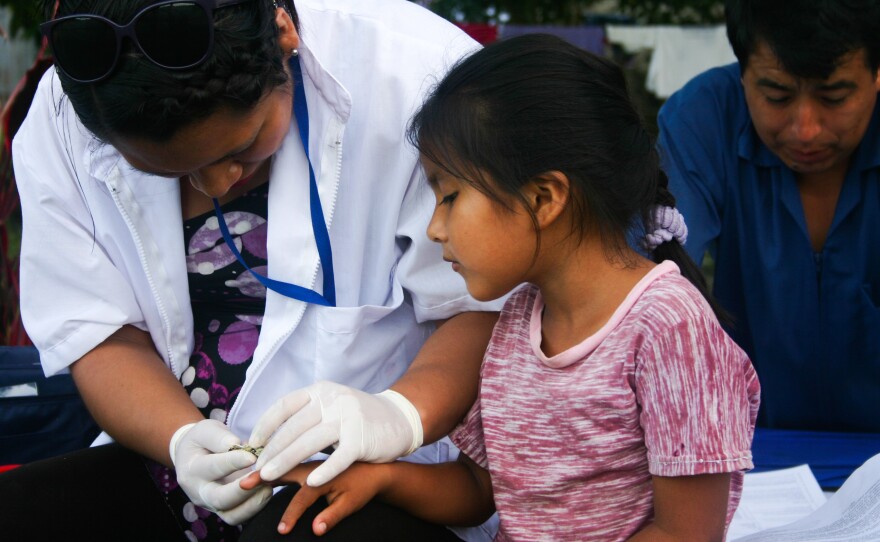 Nurse Sheena Balarezo draws blood from Linda Cutipo Ylaquijo, who's 6, as part of a huge health survey.