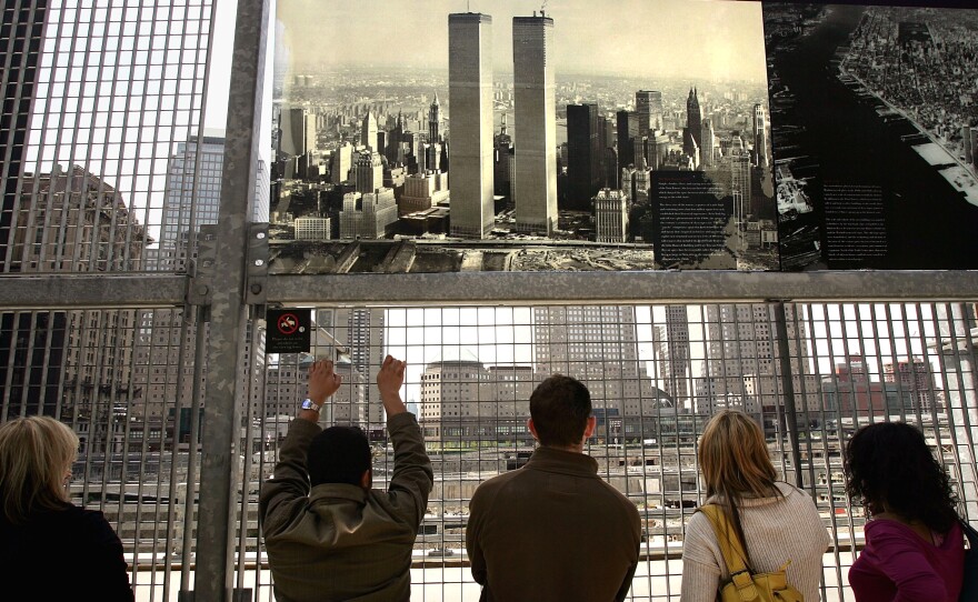 People look out at the former site of the World Trade Center in New York City in 2005, where construction had started on Freedom Tower.