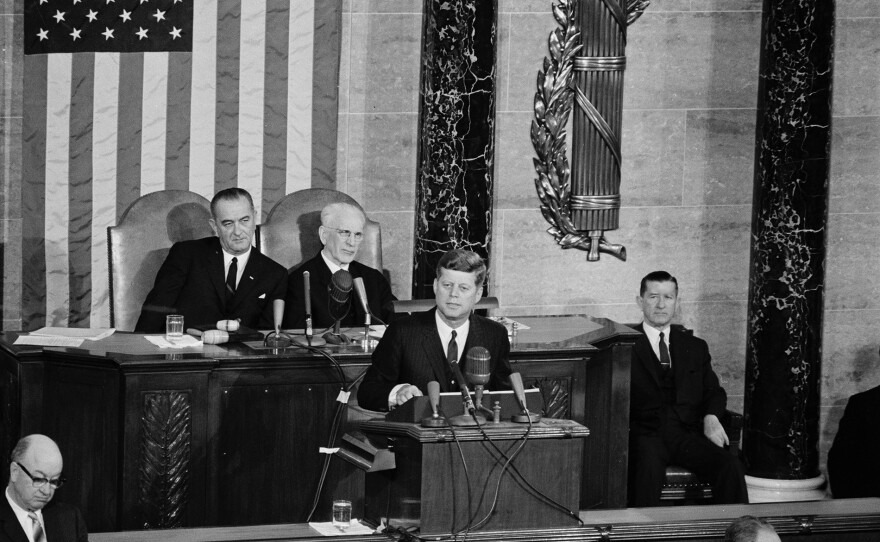 President John F. Kennedy delivering his annual address to Congress on the State of the Union in 1963. Vice President Lyndon B. Johnson (left) and Speaker of the House John W. McCormack sit behind him.