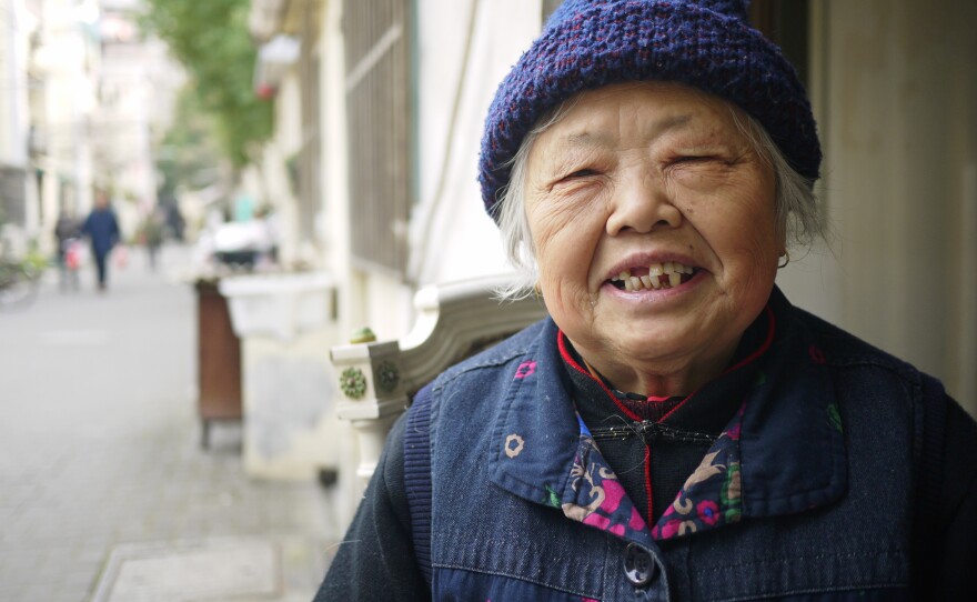 Ni Jindi, 94, sits at the entrance to Rising Peace Lane in central Shanghai. This is one of her favorite times of year, as millions of people leave the city to return to their hometowns, and Shanghai returns to its natives, like her.