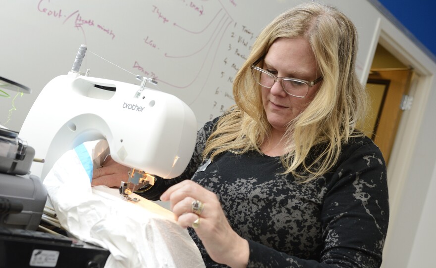 Baltimore bridal dress designer Jill Andrews says gowns and protective suits are a lot alike: tricky to put on — and take off.