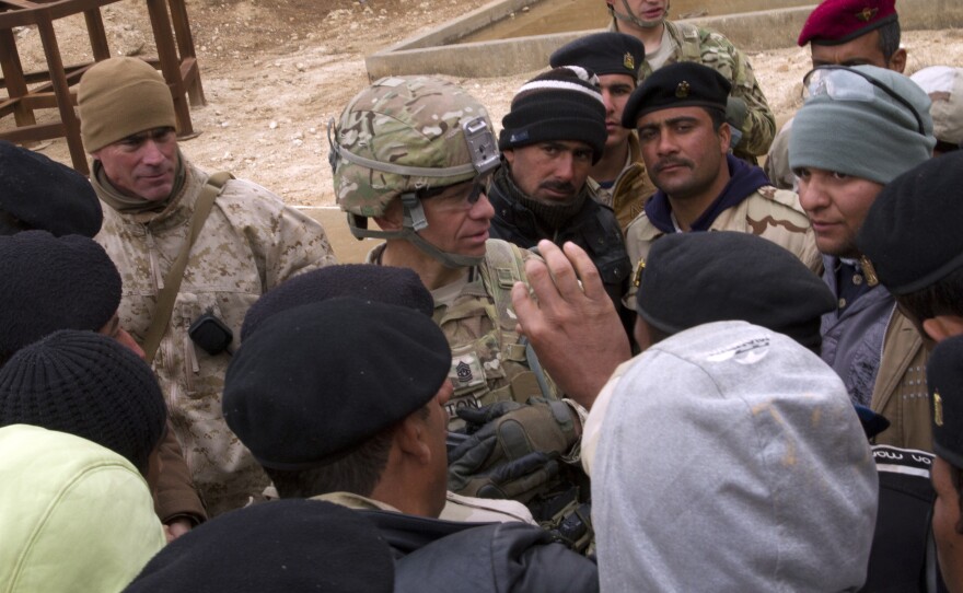 Command Sgt. Maj. Michael A. Grinston talks to Iraqi army soldiers about their training experience and living conditions at Al Asad Air Base, Iraq, Jan. 15, 2015.