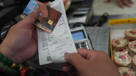 A SNAP recipient checks her balance left after purchasing food supplies with a California EBT card in Los Angeles on Oct. 31, 2025.