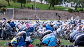 Community members kneel and pray at Colina Park on Eid Al-Adha, May 27, 2026.