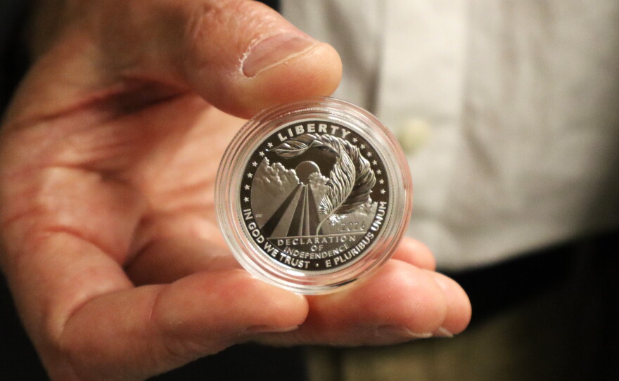 Christopher Polentz holds a coin featuring his design on Thursday, June 4, 2026.