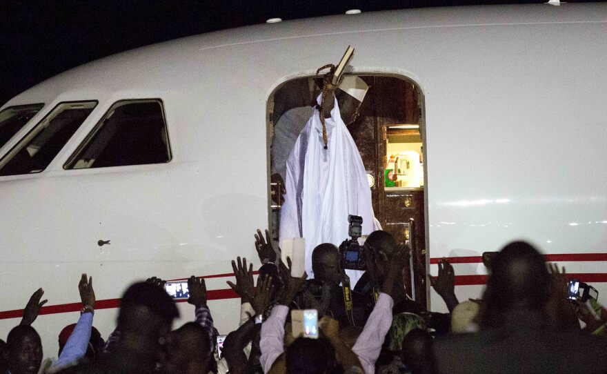 Gambia's defeated leader Yahya Jammeh waves to supporters as he departs from Banjul airport on Saturday.