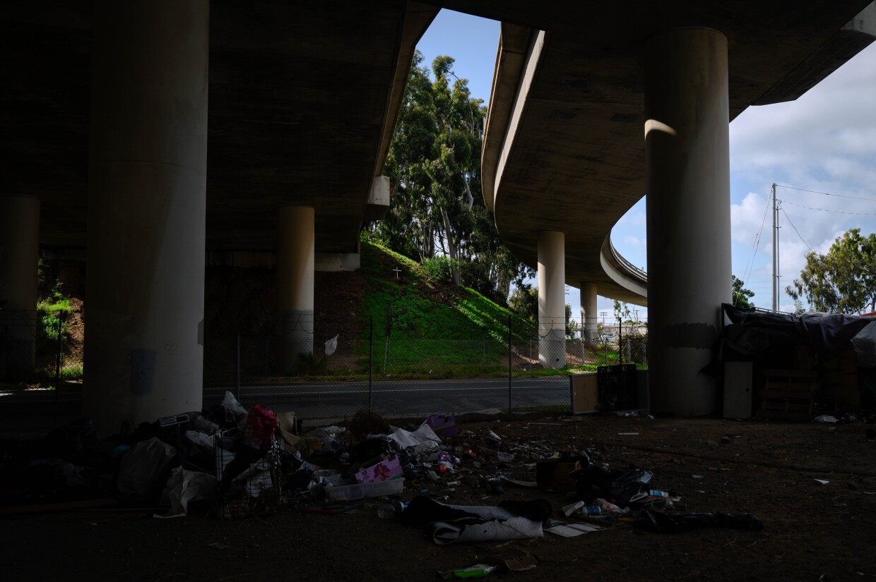 Debris is pictured next to an encampment under the I-5 freeway in National City, California on March 7, 2024. National City is the second in San Diego County to move away from a police-led response to homelessness and toward trained caseworkers.