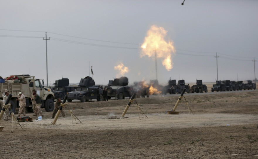 Iraqi special forces fire toward Islamic State positions near the village of Tob Zawa, outside Mosul, on Monday. Loudspeakers on the armored vehicles blared Iraqi patriotic music.