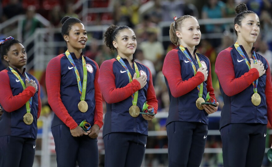 U.S. gymnasts and gold medalists (from left) Simone Biles, Gabby Douglas, Lauren Hernandez, Madison Kocian and Aly Raisman stand for the medal ceremony. The Americans lived up to expectations, overwhelming their competition.