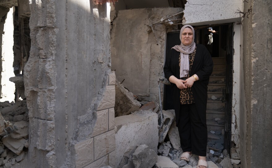 Itaf Damaj stands in the doorway of her home where she and other family members were trapped from the rubble of the strike on the mosque next door, in Jenin.