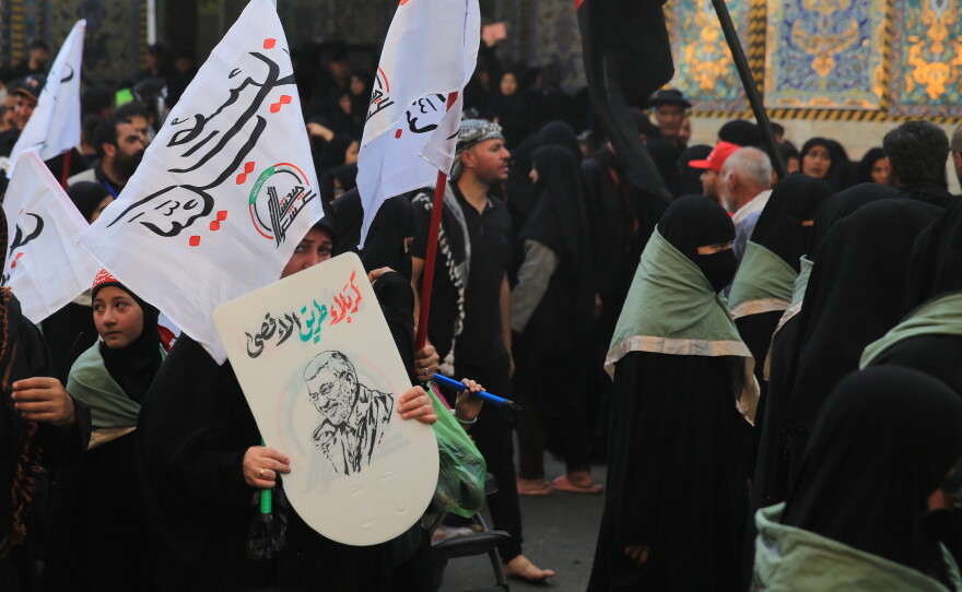 Pilgrims carry religious flags and banners during the Arbaeen pilgrimage near the Imam Hussein Shrine in Karbala, as millions of worshippers from Iraq and abroad continue to gather for the annual religious commemoration.