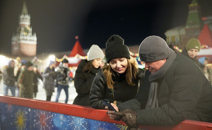 Visitors enjoy the ice rink in Red Square at the Moscow GUM State Department store with the Spasskaya Tower to the left and the Kremlin Wall in Moscow on Monday.