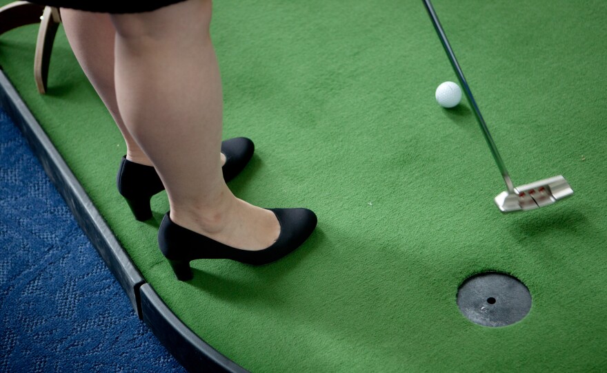 A staffer participates in the annual Democrats vs. Republicans putting challenge.