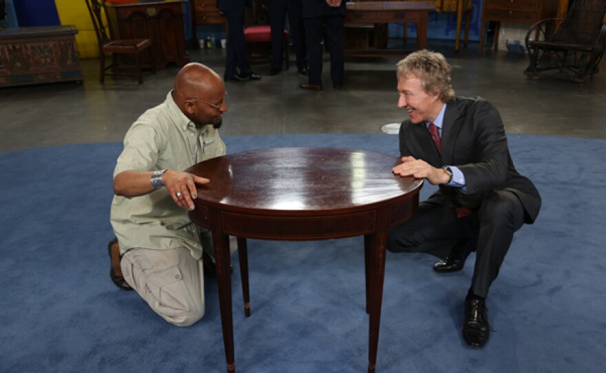 Leigh Keno (right) appraises a Federal center table, ca. 1790, for $8,000 to $12,000 in Detroit, Michigan.