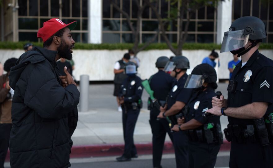 A demonstrator explains himself to an officer in riot gear during a protest Wednesday in downtown Los Angeles. The impact of Floyd's death has been felt well beyond Minneapolis' city limits.
