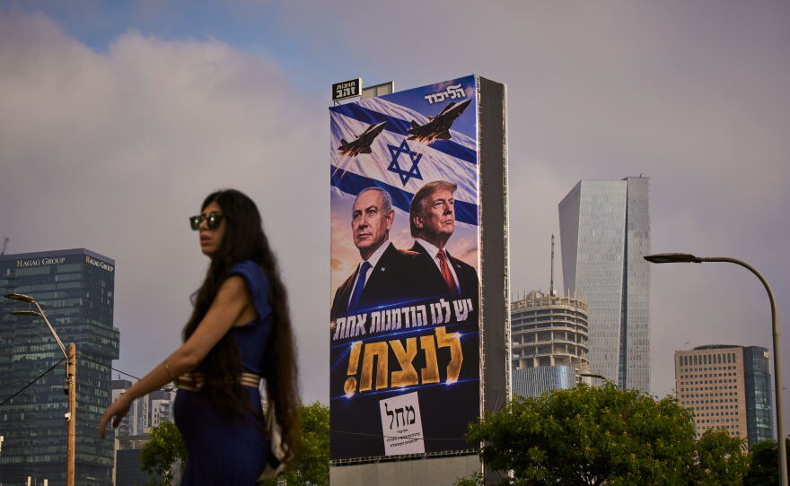 A woman walks past a Likud Party campaign billboard featuring President Trump and Israeli Prime Minister Benjamin Netanyahu, with a Hebrew message reading, "We have one opportunity to win," in Tel Aviv, Israel, on Monday.