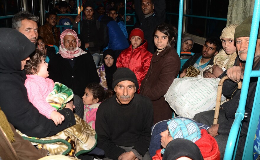 Syrian families from various eastern districts of Aleppo are evacuated by bus through Sheikh Maqsud, a Kurdish-controlled enclave between the government-held west of Aleppo and the east, on Sunday, as Syrian pro-government troops continue their advance toward rebel-controlled districts.