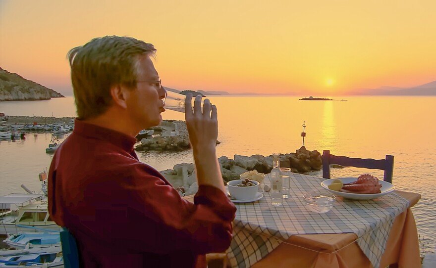 Rick sips a cloudy glass of ouzo at sunset on the Greek isle of Hydra.