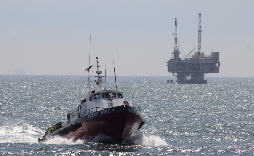 This May 16, 2015, file photo shows a service boat carrying workers back to shore from a platform off Seal Beach, Calif.