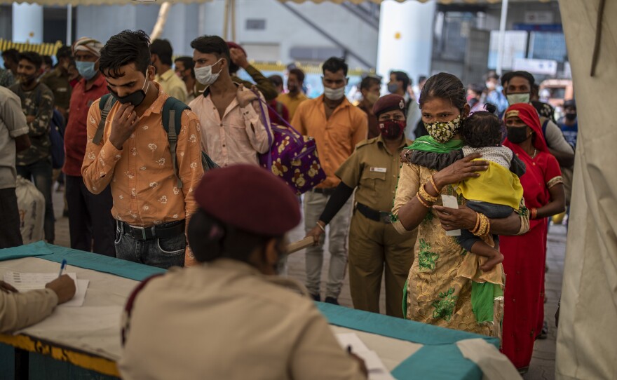 Passengers register at a counter before being tested for COVID-19 at a bus terminal on Wednesday in New Delhi.