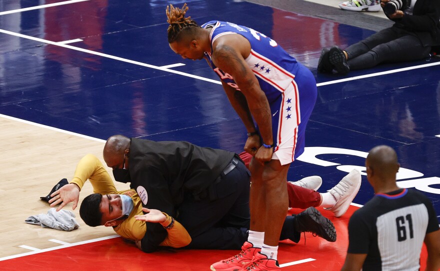 Dwight Howard of the Philadelphia 76ers looks down at a fan who ran onto the court and was tackled by security in Game Four of the Eastern Conference first round series against the Washington Wizards on Monday.