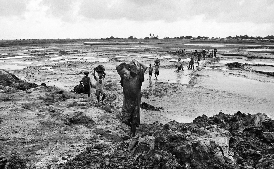 An estimated one million people from the Rohingya community are stateless in Myanmar. Here, 7-year-old Nur hauls mud with Rohingya men at a work site near one of the camps where they live.