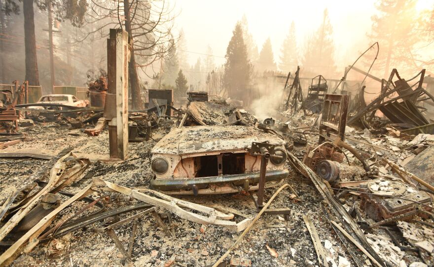 The charred remains of a vehicle and home in Paradise destroyed by the Camp Fire on Thursday.