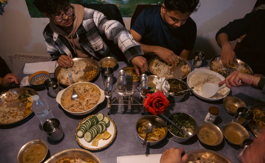 Bhagawat Dulal and Pratik Chhetri, staff members at ARU, eat together with community members and friends after soccer practice in Harrisburg, Pa., on April 16, 2025.