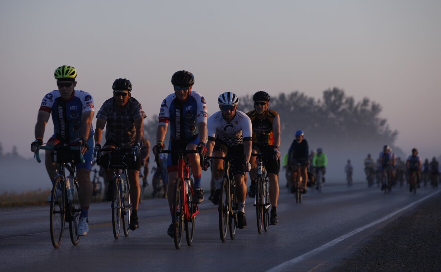 A group pf riders makes their way through the early morning fog Wednesday, July 28, as they make their way out of Emmetsburg, Iowa, on Day 4 of RAGBRAI. Riders travelled more than 100 miles that day, completing a "century ride" in honor of one of the ride's late co-founders, John Karras, who died late last year.