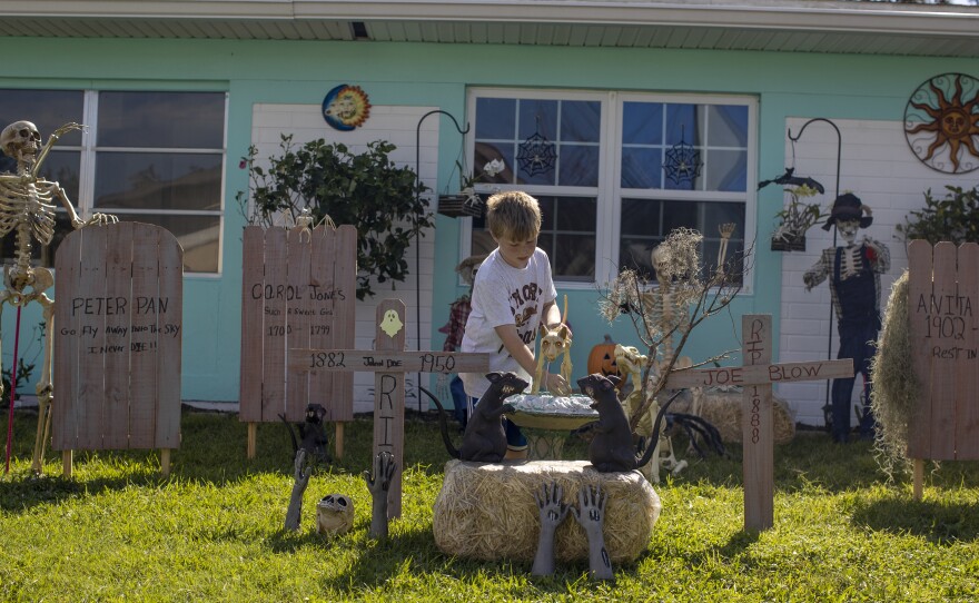 Hunter Peck adjusts Halloween decorations at his grandparents' home in North Port, Fla., on Wednesday.