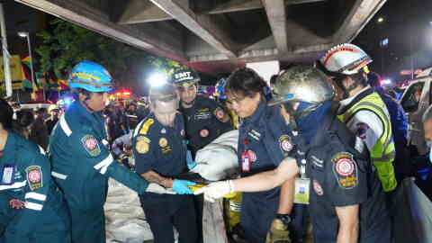 Rescuers carry the body of a victim of a fire in Bangkok, Thailand, Monday, July 13, 2026.