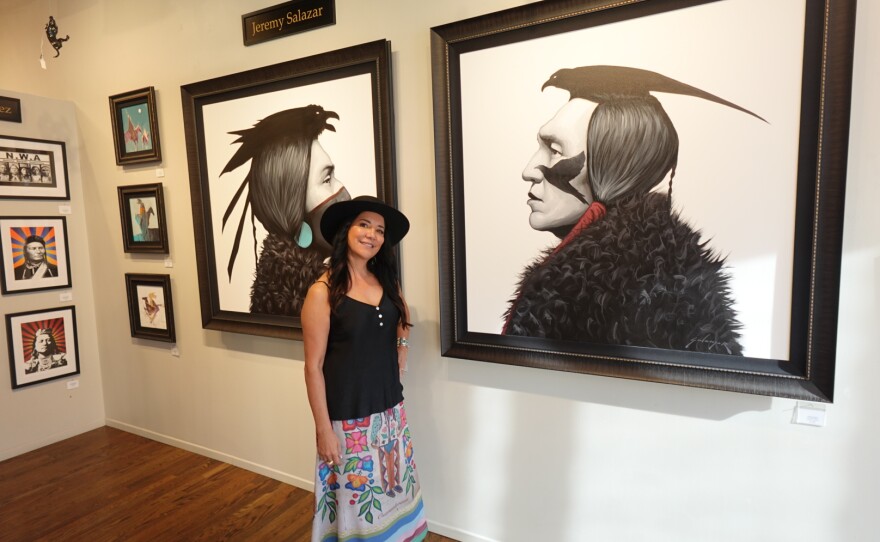 Owner of Exclusive Collections Gallery, Ruth Ann Thorn, in front of art by a Native American for Native American Heritage Month on Nov. 10th.